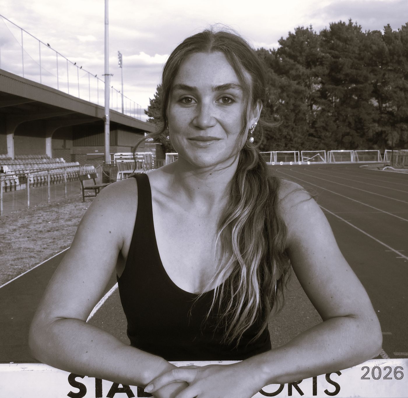 Pippa Earley leaning on a hurdle at the track
